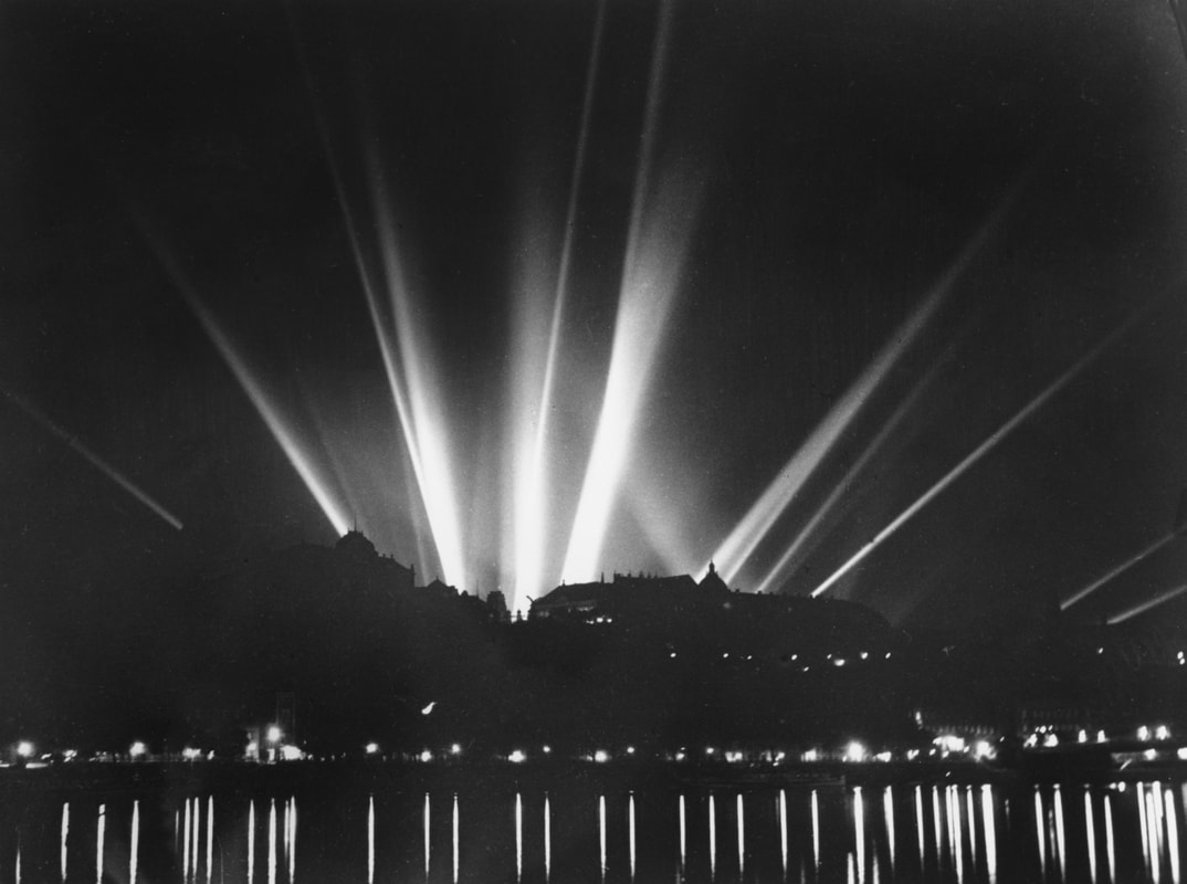 Légvédelmi fényszórók világítják meg az eget a budai Vár felett egy légoltalmi gyakorlat alkalmával, 1938. Inkey Tibor felvétele. BTM Kiscelli Múzeum Fényképgyűjtemény